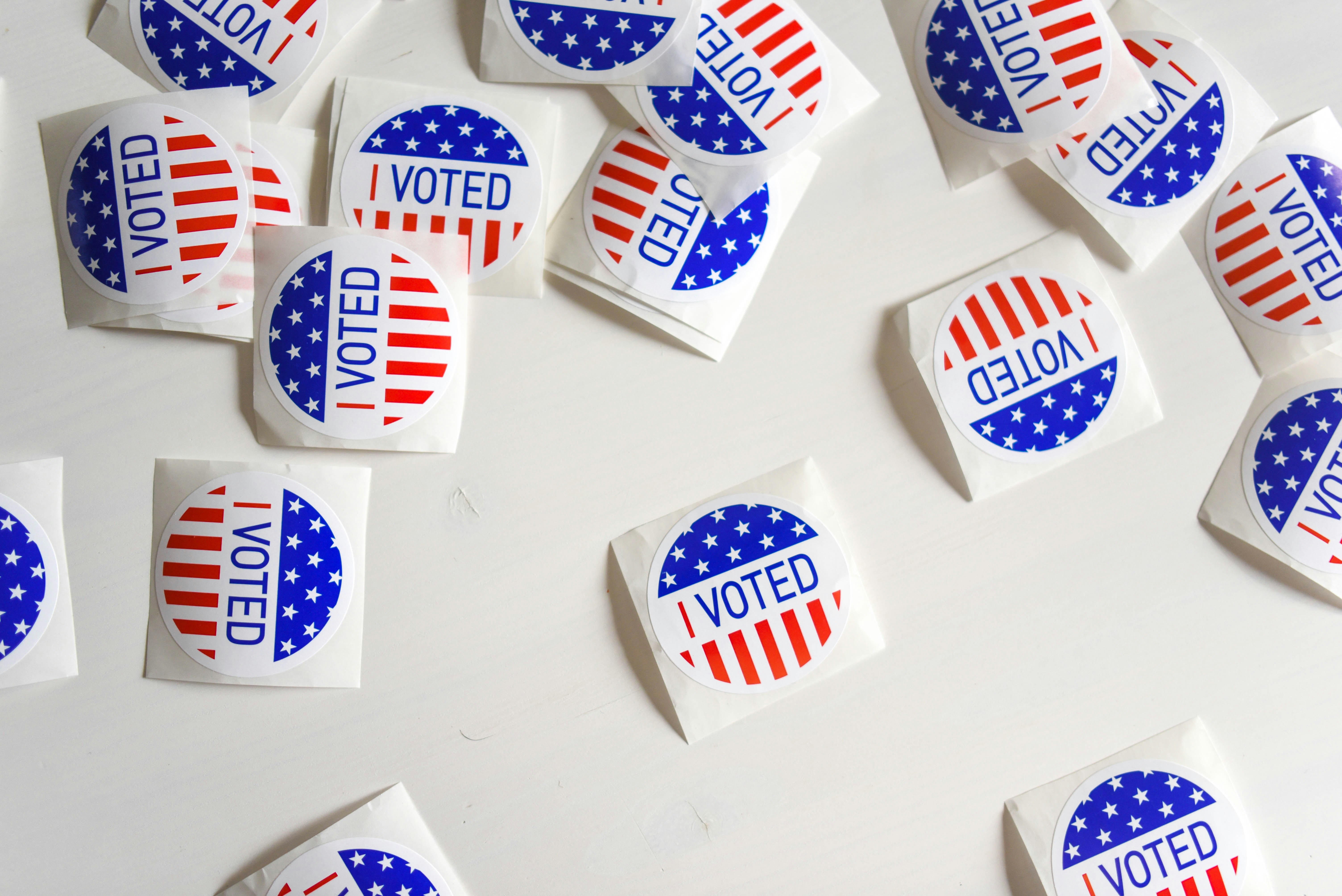 A pile of round 'I Voted' stickers in red, white, and blue.